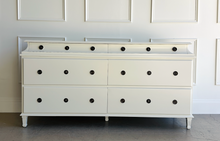 Load image into Gallery viewer, Built from solid mango wood, the Valencia dresser mixes timeless European lines with a relaxed, hand-finished patina. A stepped gallery crowns the case, while framed drawer fronts and reeded, tapered feet give the piece architectural presence. At 72" wide with six generous drawers, it brings warm, natural character and serious storage to the primary bedroom, guest suite, or sophisticated entry.
