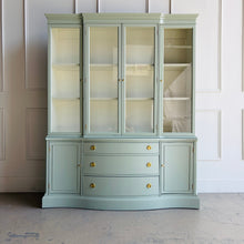 Load image into Gallery viewer, This vintage Bassett China Cabinet has been professionally lacquered in Benjamin Moore Saybrook Sage on the exterior with a creamy white interior for a bright, clean display. The classic silhouette features four glass doors on the upper hutch for showcasing china, glassware, and collections, while the lower cabinet offers a graceful serpentine front with ample closed storage. Warm brass knobs finish the look with an elegant, timeless contrast. Good Bones Furniture
