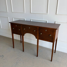 Load image into Gallery viewer, Antique bench made cherry sideboard with three drawers and tapered legs, shown in a bright white paneled room, featuring a clean architectural silhouette and warm natural wood finish. Good Bones Furniture
