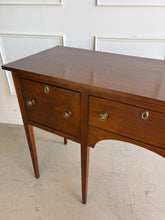 Load image into Gallery viewer, Antique bench made cherry sideboard with three drawers and tapered legs, shown in a bright white paneled room, featuring a clean architectural silhouette and warm natural wood finish. Good Bones Furniture
