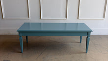Load image into Gallery viewer, This vintage coffee table pairs classic architectural details with a fresh, colorful finish. Professionally lacquered in Sherwin-Williams Moody Blue, it features a rectangular top, subtly molded apron, carved corner accents, and tapered legs with recessed panel detailing.  Good Bones Furniture
