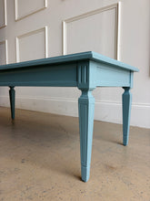 Load image into Gallery viewer, This vintage coffee table pairs classic architectural details with a fresh, colorful finish. Professionally lacquered in Sherwin-Williams Moody Blue, it features a rectangular top, subtly molded apron, carved corner accents, and tapered legs with recessed panel detailing.  Good Bones Furniture
