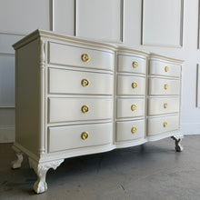 Load image into Gallery viewer, This vintage 12 drawer dresser by Continental Furniture has been professionally lacquered in Benjamin Moore Natural Linen, giving the traditional silhouette a softer, updated presence while highlighting its elegant serpentine front and carved details. Resting on sculpted claw feet with fluted corner accents, new Hepplewhite hardware. Good Bones Furniture
