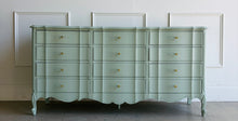 Load image into Gallery viewer, Elegant curves and generous storage give this vintage Dixie dresser a timeless presence, while its fresh custom finish makes it feel entirely current. Lacquered in a Benjamin Moore Saybrook Sage mix, the soft muted green highlights the dresser’s serpentine front, graceful cabriole legs, and classic French-inspired lines. New lucite and brass hardware. Good Bones Furniture
