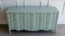 Load image into Gallery viewer, Elegant curves and generous storage give this vintage Dixie dresser a timeless presence, while its fresh custom finish makes it feel entirely current. Lacquered in a Benjamin Moore Saybrook Sage mix, the soft muted green highlights the dresser’s serpentine front, graceful cabriole legs, and classic French-inspired lines. New lucite and brass hardware. Good Bones Furniture
