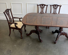 Load image into Gallery viewer, This vintage Drexel Heritage Nine Elms dining set showcases richly figured crotch mahogany veneer framed by contrasting banding. The expansive table rests on two ornately carved pedestal bases and includes three 22-inch leaves, extending it to an impressive 140 inches for large gatherings. Eight coordinating chairs—two armchairs and six side chairs. Good Bones Furniture
