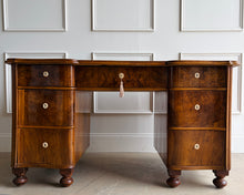 Load image into Gallery viewer, This vintage English-style pedestal desk features richly figured wood veneers, dramatic waterfall drawer fronts, and a gilt-tooled leather writing surface that gives the piece the feel of a collected European library. Influenced by Georgian Revival and campaign-style furniture, the desk blends traditional detailing with softer Art Deco curves, creating a silhouette that feels both timeless and distinctive. Good Bones Furniture
