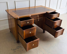 Load image into Gallery viewer, This vintage English-style pedestal desk features richly figured wood veneers, dramatic waterfall drawer fronts, and a gilt-tooled leather writing surface that gives the piece the feel of a collected European library. Influenced by Georgian Revival and campaign-style furniture, the desk blends traditional detailing with softer Art Deco curves, creating a silhouette that feels both timeless and distinctive. Good Bones Furniture
