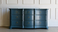Load image into Gallery viewer, Vintage Ethan Allen dresser lacquered in Sherwin Williams Rain Cloud, the muted blue-gray color gives the piece a sophisticated, updated presence. The serpentine front adds movement across all nine drawers, while fluted corner details and a stepped base bring structure and depth. New brushed brass ring hardware. Good Bones Furniture
