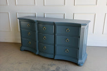 Load image into Gallery viewer, Vintage Ethan Allen dresser lacquered in Sherwin Williams Rain Cloud, the muted blue-gray color gives the piece a sophisticated, updated presence. The serpentine front adds movement across all nine drawers, while fluted corner details and a stepped base bring structure and depth. New brushed brass ring hardware. Good Bones Furniture

