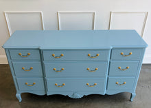 Load image into Gallery viewer, This vintage nine-drawer dresser by Ethan Allen combines generous storage with graceful traditional detailing. Professionally lacquered in a custom muted blue with soft gray undertones, the finish gives its classic silhouette a fresh, versatile look. Nine drawers provide abundant organized storage, while framed drawer fronts, a gently stepped top, curved apron, carved shell motif, and cabriole-style legs preserve its vintage character. Good Bones Furniture
