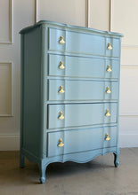 Load image into Gallery viewer, A classic French Provincial silhouette refreshed with a clean, modern lacquer finish. This vintage five-drawer chest features softly shaped drawer fronts, a gently serpentine apron, and cabriole-style feet that give it an elegant, airy profile. Finished in a custom Parma Gray mix, the color reads as a sophisticated blue-gray that shifts beautifully with natural light, and it’s completed with polished brass ginkgo leaf hardware for a warm, sculptural contrast. Good Bones Furniture
