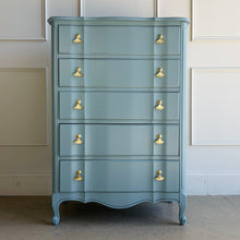 Load image into Gallery viewer, A classic French Provincial silhouette refreshed with a clean, modern lacquer finish. This vintage five-drawer chest features softly shaped drawer fronts, a gently serpentine apron, and cabriole-style feet that give it an elegant, airy profile. Finished in a custom Parma Gray mix, the color reads as a sophisticated blue-gray that shifts beautifully with natural light, and it’s completed with polished brass ginkgo leaf hardware for a warm, sculptural contrast. Good Bones Furniture
