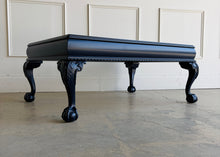 Load image into Gallery viewer, This vintage coffee table pairs traditional craftsmanship with a fresh, tailored finish. Lacquered in Sherwin Williams Naval, the deep blue tone gives the piece a bold, sophisticated presence while highlighting its elegant silhouette. Ball and claw feet and carved detailing lend classic character, while the inset glass top keeps the overall look light and polished. Good Bones Furniture
