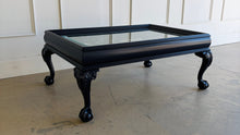 Load image into Gallery viewer, This vintage coffee table pairs traditional craftsmanship with a fresh, tailored finish. Lacquered in Sherwin Williams Naval, the deep blue tone gives the piece a bold, sophisticated presence while highlighting its elegant silhouette. Ball and claw feet and carved detailing lend classic character, while the inset glass top keeps the overall look light and polished. Good Bones Furniture
