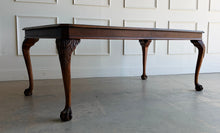 Load image into Gallery viewer, A timeless Henredon dining table crafted with exceptional attention to detail and beautiful figured mahogany veneers. The richly grained top showcases dramatic cathedral patterns framed by a contrasting mahogany border, while the carved cabriole legs with ball-and-claw feet reflect classic Chippendale-inspired design. Good Bones Furniture
