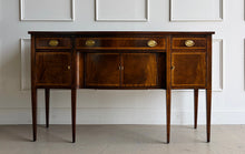 Load image into Gallery viewer, Vintage Hickory Chair sideboard showcasing classic Federal-inspired styling with beautifully banded mahogany veneers, graceful serpentine lines, and tapered legs. The thoughtfully designed layout includes three drawers above three cabinet compartments, offering versatile storage for dining essentials, serving pieces, or barware. Rich mahogany grain, satin brass hardware, and refined inlay details. Good Bones Furniture
