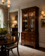 Load image into Gallery viewer, Hickory Chair mahogany display cabinet with glass doors styled in a high-end dining room with layered lighting, showcasing traditional furniture, brass accents, and a formal dining setting
Good Bones Furniture

