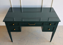 Load image into Gallery viewer, This beautifully refinished vintage desk offers timeless design with a fresh, designer-inspired finish. Professionally lacquered in Sherwin-Williams Rookwood Sash Green in a high-gloss sheen, it makes a bold yet sophisticated statement while preserving its classic mid-century silhouette. Five spacious drawers provide practical storage for office essentials, and the new antiqued brass hardware adds warmth and elegance against the rich green lacquer. Good Bones Furniture
