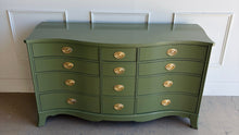 Load image into Gallery viewer, This vintage mahogany dresser makes a strong statement with its elegant serpentine front and generous twelve-drawer layout. The shaped case gives the piece movement and softness, while the symmetrical drawer configuration keeps the overall look balanced and refined. Professionally lacquered in Farrow &amp; Ball Bancha, the finish brings a rich olive green depth that feels classic, tailored, and quietly dramatic. Good Bones Furniture
