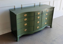 Load image into Gallery viewer, This vintage mahogany dresser makes a strong statement with its elegant serpentine front and generous twelve-drawer layout. The shaped case gives the piece movement and softness, while the symmetrical drawer configuration keeps the overall look balanced and refined. Professionally lacquered in Farrow &amp; Ball Bancha, the finish brings a rich olive green depth that feels classic, tailored, and quietly dramatic. Good Bones Furniture

