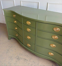 Load image into Gallery viewer, This vintage mahogany dresser makes a strong statement with its elegant serpentine front and generous twelve-drawer layout. The shaped case gives the piece movement and softness, while the symmetrical drawer configuration keeps the overall look balanced and refined. Professionally lacquered in Farrow &amp; Ball Bancha, the finish brings a rich olive green depth that feels classic, tailored, and quietly dramatic. Good Bones Furniture
