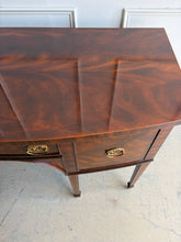 Load image into Gallery viewer, This vintage Maitland-Smith sideboard showcases the brand’s renowned craftsmanship and elegant neoclassical styling. Crafted with richly figured mahogany veneers, the serpentine front and graceful arched apron create a sophisticated silhouette, while brass lion-head hardware and tapered inlaid legs add refined details throughout. Good Bones Furniture
