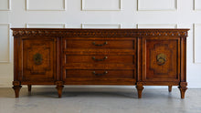 Load image into Gallery viewer, This vintage Mediterranean/ Spanish Revival credenza dresser has the scale, craftsmanship, and presence that make 1970s American case goods so collectible. The design features a carved scrolling frieze, burl veneer door panels, architectural legs, and original brass ring hardware with geometric backplates. Good Bones Furniture
