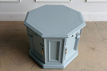 Load image into Gallery viewer, Professionally lacquered in Benjamin Moore Boothbay Gray, this vintage octagonal accent cabinet blends Hollywood Regency glamour with architectural neo-classical detailing. The octagonal silhouette, recessed panel molding, and arched faux-door styling give the piece strong boutique showroom presence. End table. Good Bones Furniture
