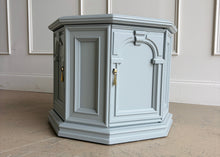 Load image into Gallery viewer, Professionally lacquered in Benjamin Moore Boothbay Gray, this vintage octagonal accent cabinet blends Hollywood Regency glamour with architectural neo-classical detailing. The octagonal silhouette, recessed panel molding, and arched faux-door styling give the piece strong boutique showroom presence. End table. Good Bones Furniture
