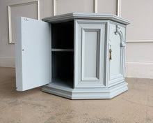 Load image into Gallery viewer, Professionally lacquered in Benjamin Moore Boothbay Gray, this vintage octagonal accent cabinet blends Hollywood Regency glamour with architectural neo-classical detailing. The octagonal silhouette, recessed panel molding, and arched faux-door styling give the piece strong boutique showroom presence. End table. Good Bones Furniture
