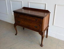 Load image into Gallery viewer, This vintage Queen Anne-style two drawer chest features richly figured wood grain, graceful cabriole legs, carved corner details, and classic brass hardware. The compact scale makes it especially versatile as a bedside chest, entryway piece, small dresser, or accent cabinet. Good Bones Furniture

