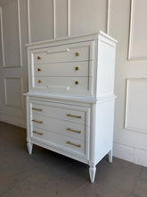 Load image into Gallery viewer, This vintage Thomasville chest on chest provides generous storage within a tall, space-conscious silhouette. Professionally lacquered in Benjamin Moore White Dove, its softly warm off-white finish has subtle creamy undertones that feel bright without appearing stark. Six spacious drawers are arranged across two architecturally framed sections, creating the appearance of stacked chests. New brass knobs and linear pulls. Good Bones Furniture
