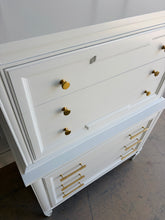 Load image into Gallery viewer, This vintage Thomasville chest on chest provides generous storage within a tall, space-conscious silhouette. Professionally lacquered in Benjamin Moore White Dove, its softly warm off-white finish has subtle creamy undertones that feel bright without appearing stark. Six spacious drawers are arranged across two architecturally framed sections, creating the appearance of stacked chests. New brass knobs and linear pulls. Good Bones Furniture
