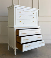 Load image into Gallery viewer, This vintage Thomasville chest on chest provides generous storage within a tall, space-conscious silhouette. Professionally lacquered in Benjamin Moore White Dove, its softly warm off-white finish has subtle creamy undertones that feel bright without appearing stark. Six spacious drawers are arranged across two architecturally framed sections, creating the appearance of stacked chests. New brass knobs and linear pulls. Good Bones Furniture
