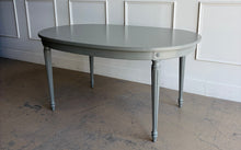 Load image into Gallery viewer, This vintage Thomasville dining table features a clean oval silhouette, tapered fluted legs, and understated neoclassical detailing that gives it a tailored, architectural presence without feeling overly formal. Custom lacquered in Lauriston Stone. Good Bones Furniture
