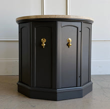 Load image into Gallery viewer, This vintage end table has been professionally refinished in Sherwin-Williams Urbane Bronze, creating a sophisticated contrast against its natural travertine stone top. The rich charcoal finish highlights the table's distinctive faceted silhouette while allowing the warm tones and organic texture of the travertine to take center stage. Good Bones Furniture

