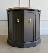 Load image into Gallery viewer, This vintage end table has been professionally refinished in Sherwin-Williams Urbane Bronze, creating a sophisticated contrast against its natural travertine stone top. The rich charcoal finish highlights the table's distinctive faceted silhouette while allowing the warm tones and organic texture of the travertine to take center stage. Good Bones Furniture

