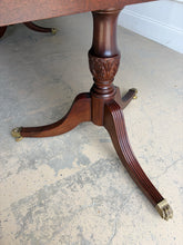 Load image into Gallery viewer, Classic proportions and refined craftsmanship give this vintage banded mahogany dining table its timeless appeal. The rich mahogany top is framed by a contrasting banded edge that adds subtle visual definition, while the double pedestal base brings balance, elegance, and stability. Carved pedestal details and brass-capped feet. Good Bones Furniture
