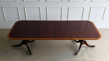 Load image into Gallery viewer, Classic proportions and refined craftsmanship give this vintage banded mahogany dining table its timeless appeal. The rich mahogany top is framed by a contrasting banded edge that adds subtle visual definition, while the double pedestal base brings balance, elegance, and stability. Carved pedestal details and brass-capped feet. Good Bones Furniture
