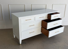 Load image into Gallery viewer, This vintage dresser by Kindel Furniture blends heirloom craftsmanship with a fresh, tailored update. Professionally lacquered in Benjamin Moore White Dove, the finish gives the piece a soft, warm white presence that feels crisp without feeling stark. Fluted corner posts add subtle classical detail, while slim brass bar pulls and brass-capped feet introduce a refined modern contrast. Good Bones Furniture
