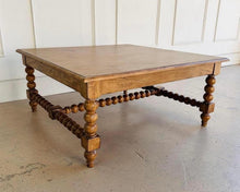 Load image into Gallery viewer, The Wellmington Coffee Table is a beautiful statement piece that brings both character and functionality to any living space. Crafted from solid Mango wood, it features stunning large bobbin legs and cross braces that highlight its traditional craftsmanship. The substantial square design ensures ample surface area, making it perfect for both decorative displays and everyday use. Good Bones Furniture
