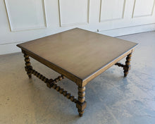 Load image into Gallery viewer, The Wellmington Coffee Table is a beautiful statement piece that brings both character and functionality to any living space. Crafted from solid Mango wood, it features stunning large bobbin legs and cross braces that highlight its traditional craftsmanship. The substantial square design ensures ample surface area, making it perfect for both decorative displays and everyday use. Good Bones Furniture

