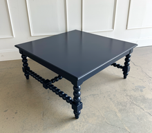 Load image into Gallery viewer, The Wellmington Coffee Table is a beautiful statement piece that brings both character and functionality to any living space. Crafted from solid Mango wood, it features stunning large bobbin legs and cross braces that highlight its traditional craftsmanship. The substantial square design ensures ample surface area, making it perfect for both decorative displays and everyday use. Good Bones Furniture
