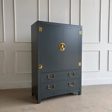 Load image into Gallery viewer, The White Furniture Co. Chin Hua Armoire is an iconic statement piece with a clean, architectural silhouette and unmistakable campaign-inspired details. Finished in Farrow &amp; Ball Studio Green, this piece brings dramatic, saturated color to the classic Chin Hua design language—sharp lines, recessed panel doors, and bold brass accents that feel timeless rather than trendy. Use it as a wardrobe, bar cabinet, or elevated storage anywhere you want a true focal point.
