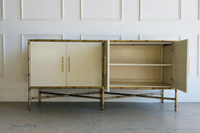Load image into Gallery viewer, Ambella Home four-door chinoiserie cabinet with doors open to reveal spacious interior shelving, framed in faux bamboo metal with a neutral linen finish.

