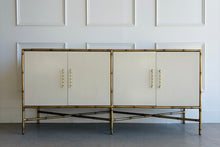 Load image into Gallery viewer, Front view of the Ambella Home Chinoiserie Cabinet featuring metal faux bamboo framing, four linen-finished doors, and satin brass bamboo-style pulls in a Palm Beach–inspired design.
