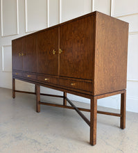 Load image into Gallery viewer, Side profile of Basil Sideboard highlighting bookmatched walnut burl panels, brass hardware, and tall legs with elegant X-stretcher support.
