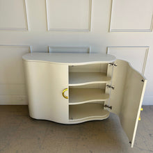 Load image into Gallery viewer, Highland House Jules Cabinet with doors open, revealing curved interior shelving and maple construction behind a creamy white lacquered exterior by Good Bones Furniture.
