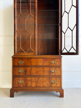 Load image into Gallery viewer, A true heirloom piece from Hickory Chair, this cabinet showcases everything that defines high-end traditional furniture—exceptional materials, precise craftsmanship, and timeless design. The case is wrapped in beautifully bookmatched crotch mahogany veneer, creating dramatic movement across the drawer fronts, while the glazed doors feature geometric muntins that give the piece a tailored, architectural feel. Good Bones Furniture

